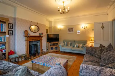 a living room with a couch and a fireplace at The Old Post Office in Grange Over Sands