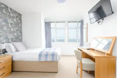 a bedroom with a bed and a desk with a computer at Hotel Santa Maria - formerly Daishs Blackpool in Blackpool