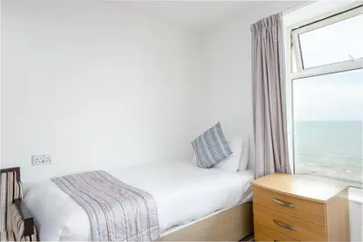 a bedroom with a bed and a window with the ocean at Hotel Santa Maria - formerly Daishs Blackpool in Blackpool
