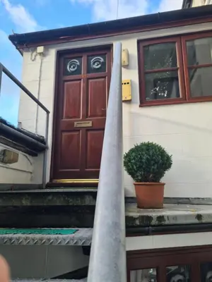 a house with a door and a plant on the steps at Brown Cow Apartment in Dalton in Furness