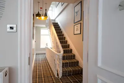 a hallway with a staircase withbrown tiles on the floor at Blackbird Luxury Apartments Room 5 in Blackpool