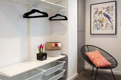a walk in closet with white shelves and a chair at Blackbird Luxury Apartments Room 5 in Blackpool