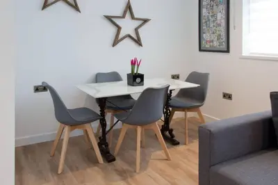 a dining room table with four chairs and a white table at Blackbird Luxury Apartments Room 5 in Blackpool