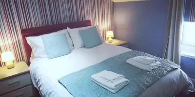 a bedroom with a bed with towels on it at Northdene Theatre Hotel in Blackpool