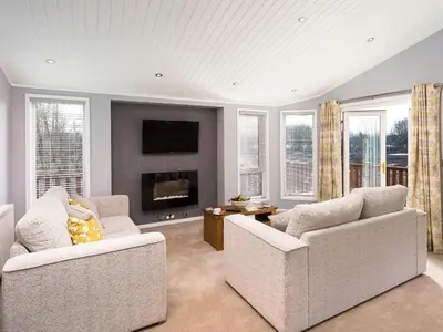 a living room with two couches and a fireplace at Waternook Lodge in Carnforth