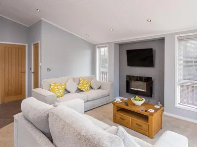 a living room with a couch and a fireplace at Waternook Lodge in Carnforth