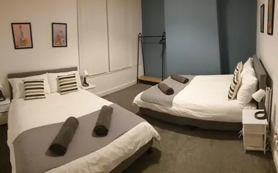 two beds in a room with at 4 Bedrooms, Sleeps 10, Near LFC & EFC in Liverpool