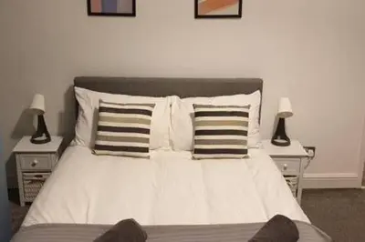 a bedroom with a bed with pillows and two lamps at 4 Bedrooms, Sleeps 10, Near LFC & EFC in Liverpool