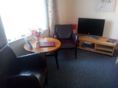 a living room with a table and a television at Aparthotel Blackpool in Blackpool