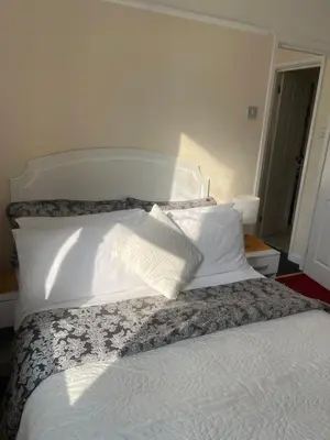 a bedroom with a bed with white sheets and pillows at Aparthotel Blackpool in Blackpool