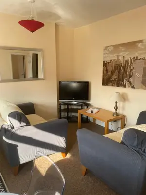 a living room with two couches and a flat screen tv at Aparthotel Blackpool in Blackpool