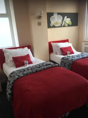 a hotel room with two beds with red sheets at Aparthotel Blackpool in Blackpool