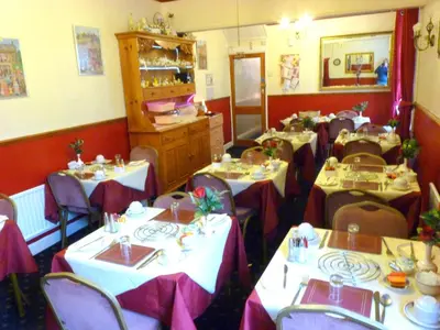 a restaurant with white tables and purple chairs at The Berkswell in Blackpool