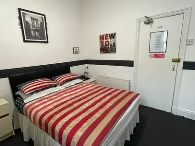 a bedroom with a bed with a striped blanket at Manhattan Hotel in Blackpool