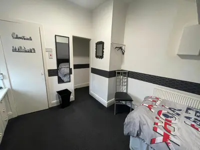 a bedroom with a bed and a sink and a mirror at Manhattan Hotel in Blackpool