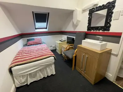 a small bedroom with a bed and a sink at Manhattan Hotel in Blackpool