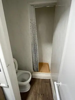 a small bathroom with a toilet and a shower at Manhattan Hotel in Blackpool
