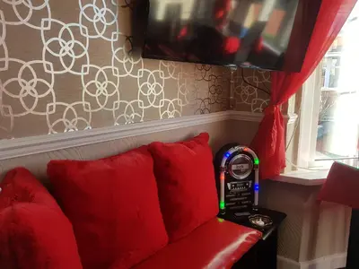a watch sitting on a red couch with red pillows at A&P at The Sheron House in Blackpool