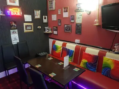 a dining room with a table and a colorful booth at A&P at The Sheron House in Blackpool