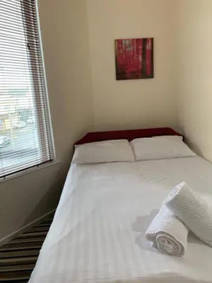 a white bed in a room with a window at OYO Wave Crest Hotel in Blackpool