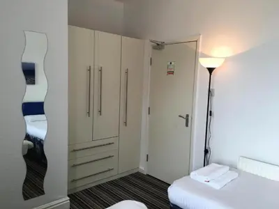 a small room with a bed and a closet at OYO Wave Crest Hotel in Blackpool