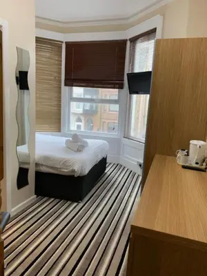 a hotel room with a bed and a window at OYO Wave Crest Hotel in Blackpool