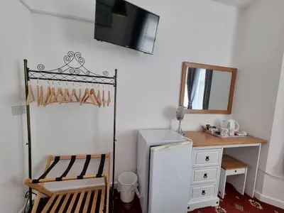 a room with a chair and a desk and a mirror at The Cameo in Blackpool