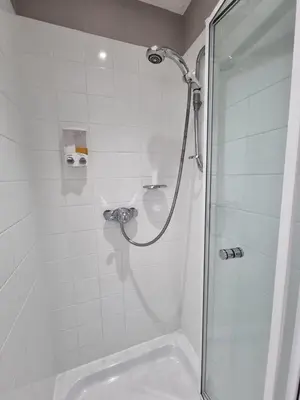 a shower with a glass door next to a sink at The Cameo in Blackpool