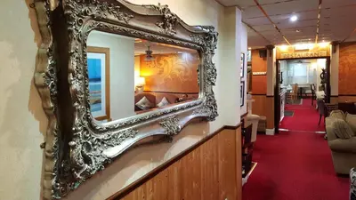 an ornate mirror on a wall in a hallway at The Regal Hotel in Blackpool