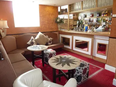 a bar with a couch and tables in a room at The Regal Hotel in Blackpool
