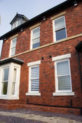 a red brick house with white windows at Breck Apartments by Central Beach Leisure Ltd in Poulton le Fylde