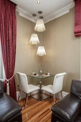 a dining room with a table and white chairs at Breck Apartments by Central Beach Leisure Ltd in Poulton le Fylde