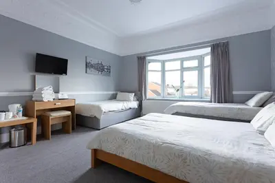 a hotel room with two beds and a window at Orrell Park Hotel in Liverpool