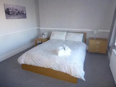 a bedroom with a bed with two towels on it at Orrell Park Hotel in Liverpool