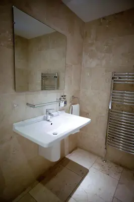 a bathroom with a white sink and a mirror at Mitton Hall Hotel in Clitheroe