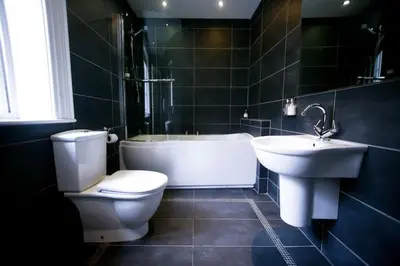 a bathroom with a toilet and a tub and a sink at Mitton Hall Hotel in Clitheroe