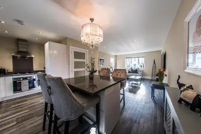 a kitchen and living room with a table and chairs at Courtyard Holiday Homes in Southport