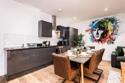 a kitchen and dining room with a table and chairs at SGT Peppers Mathew Street Apartments By Happy Days in Liverpool