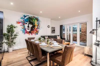 a dining room with a table and chairs at SGT Peppers Mathew Street Apartments By Happy Days in Liverpool