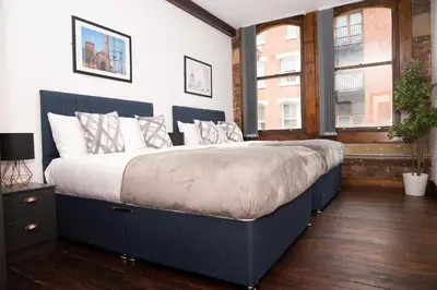 a large bed in a room with a window at 27 Stanley Street Aparthotel by UStay in Liverpool