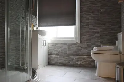 a bathroom with a toilet and a window at 27 Stanley Street Aparthotel by UStay in Liverpool