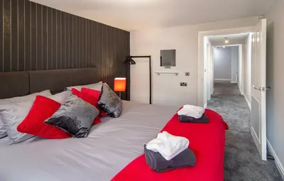 a bedroom with a large white bed with red pillows at 2 Bedrooms Sleeps 7 Near Top Blackpool Attractions in Blackpool
