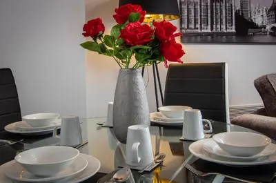 a table with a vase with red roses on it at 2 Bedrooms Sleeps 7 Near Top Blackpool Attractions in Blackpool