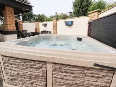 a hot tub on the patio of a house at Mayfield Cottage in Blackpool