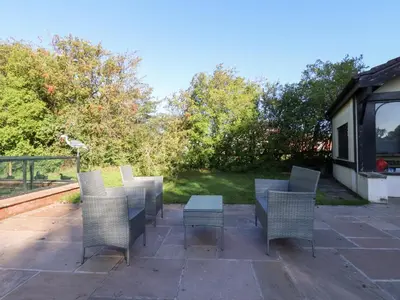 a group of chairs and a table on a patio at Mayfield Cottage in Blackpool