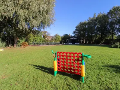 a red bench in the grass in a field at Mayfield Cottage in Blackpool