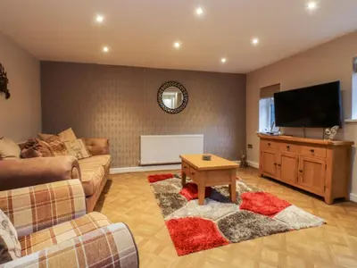 a living room with a couch and a flat screen tv at Mayfield Cottage in Blackpool