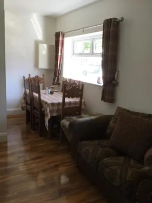 a living room with a table and a couch and a window at Grooms cottage in Thornton
