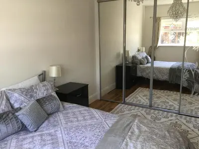 a bedroom with a bed and a mirror at Grooms cottage in Thornton