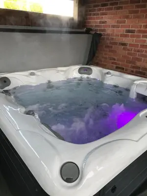 a jacuzzi bath tub with purple dye in it at Grooms cottage in Thornton